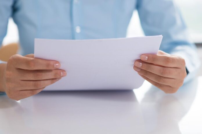 foglio tra le mani Avviso bonario in vacanza